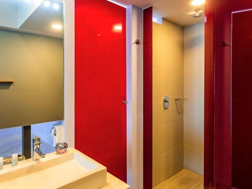 梅里达Ibis Styles Merida Galerias的一间带红色淋浴间和盥洗盆的浴室