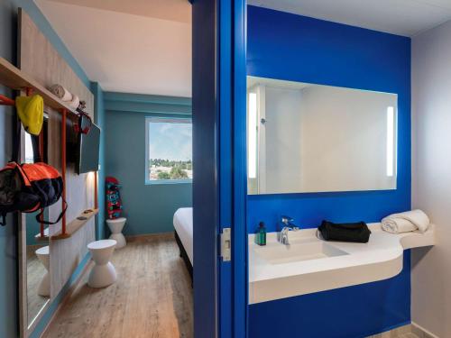 阿瓜斯卡连特斯ibis budget Aguascalientes Norte的浴室设有白色水槽和蓝色的墙壁