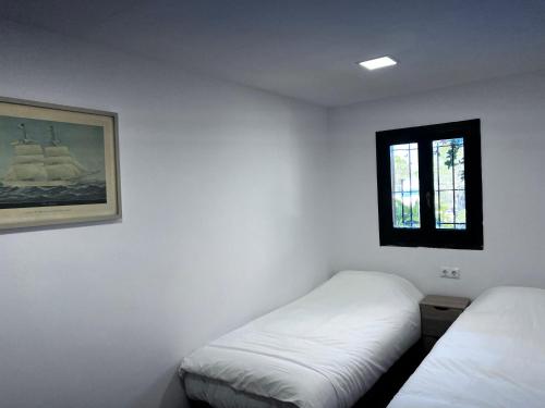 卡隆赫La casa Linda con terraza y vistas al mar的白色的客房设有两张床和窗户。