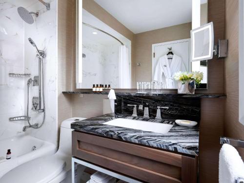 卡尔加里Fairmont Palliser的浴室配有盥洗盆、卫生间和浴缸。