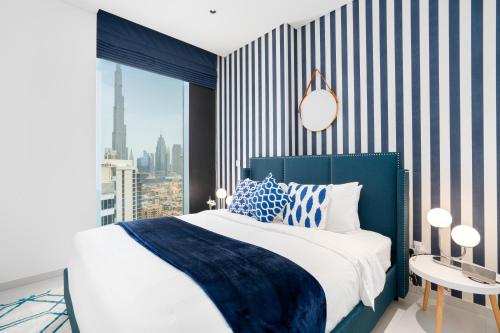 迪拜Ultimate Stay / 4 Beds / Burj Khalifa View / Ultra Modern / Business Bay的卧室配有蓝色和白色的床和窗户。