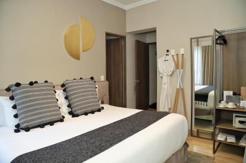 墨西哥城Agata Hotel Boutique & Spa的一间卧室配有一张大床和两个枕头