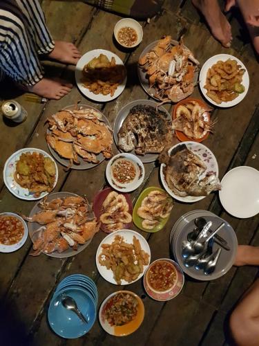 阁遥岛Antonio's ko yao noi BED & Pool的一张桌子上放着许多盘子的食物