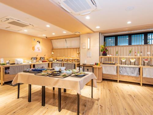 京都HOTEL ABEST GRANDE KYOTO KIYOMIZU的一个大厨房,配有餐桌和食物