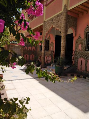 瓦尔扎扎特Villa Eden的一座花粉色的建筑的庭院