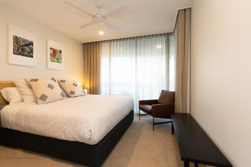玛志洛COTTON TREE CORNER@The Cosmopolitan Unit 10509的卧室配有床、椅子和窗户。