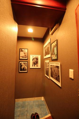 东京Hotel OLDSWING Adult Only的走廊上墙上挂有照片,地板上挂有鞋子