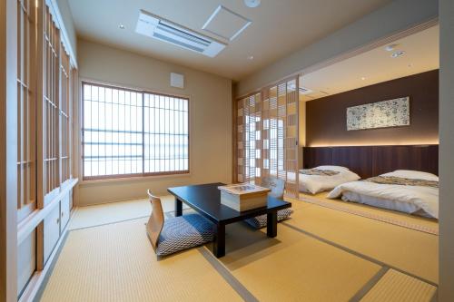 京都Nishiyama Ryokan - 1953年創業的一间卧室配有一张床、一张桌子和一张桌子