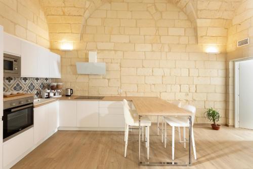 莱切DonCarlo Suite Relais - Free Parking-parcheggio gratuito的厨房配有木桌和白色橱柜。