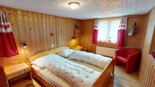 布拉腾Rosenhof RH1的一间卧室配有一张大床和一张红色椅子