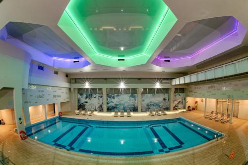 拉辛Citi Hotel's Warszawa-Falenty的一座带天花板的建筑中的游泳池