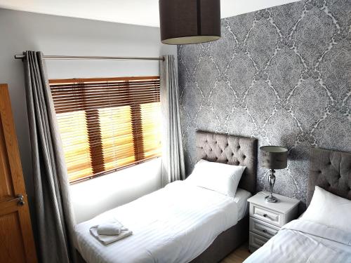 布拉尼Foxhollow House Suite的一间卧室设有两张床和窗户。