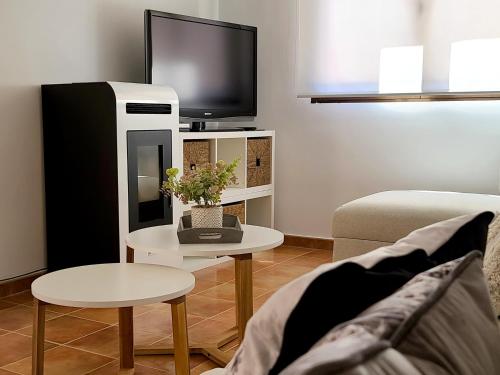 LanzahitaEl Escondite de Gredos的客厅配有电视、沙发和桌子