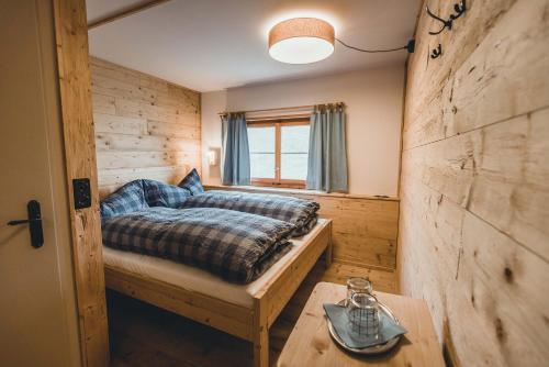 阿罗萨Alpenblick Bergrestaurant & Hotel的一间卧室设有一张床和木墙