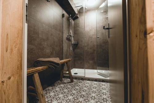 阿罗萨Alpenblick Bergrestaurant & Hotel的带淋浴、长凳和步入式淋浴间的浴室