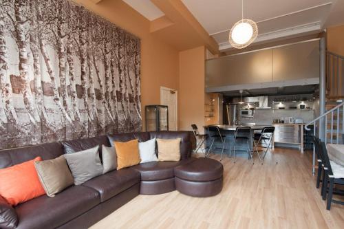 爱丁堡Royal Mile Mansions by Edinburgh City Apartments的一间带真皮沙发的客厅和一间厨房