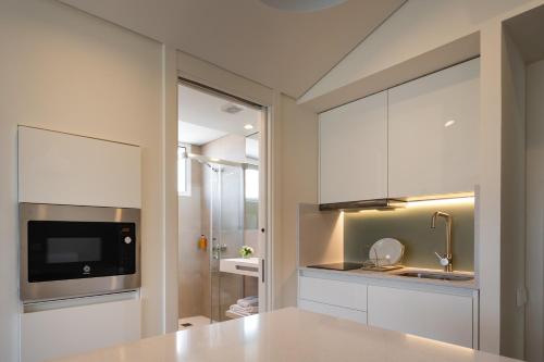 QuintanadueñasPENSION QUINTA EL RETIRO Habitación tipo Apartamento的厨房配有白色橱柜和水槽