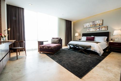 瓜达拉哈拉Square Small Luxury Hotel - Providencia的配有一张床和一把椅子的酒店客房