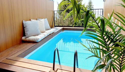 Geva Binyaminקסם היקינטון-סוויטת יוקרה的露台的游泳池,旁边是沙发