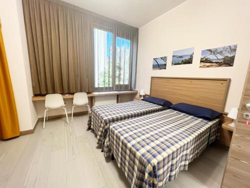 蒙扎Sissi Comfort Rooms Foresteria Lombarda的酒店客房,配有两张床和两把椅子