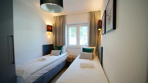 卡尔帕奇Apartamenty EverySky - Słowackiego 5a-b的酒店客房设有两张床和窗户。