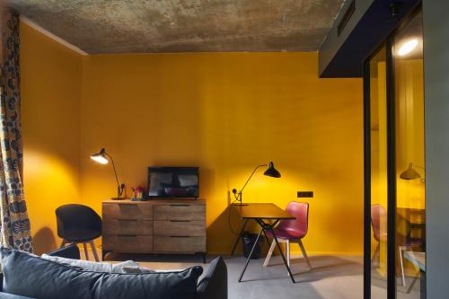 波尔多Hotel La Zoologie & Spa Bordeaux的客厅设有黄色的墙壁和桌椅