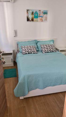奈维斯Dora的一间卧室配有一张带蓝色棉被的床
