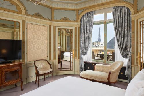 巴黎拉斐尔酒店的一间卧室设有一张床、一台电视和一个阳台。