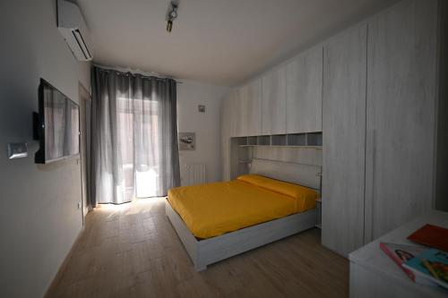 卡利亚里eliterooms的一间卧室设有黄色的床和窗户。