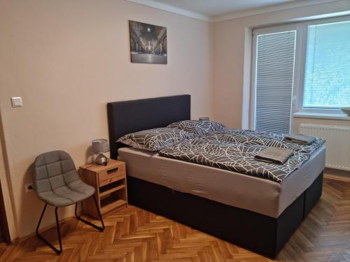 StrekovUbytovanie Na Hlavnej的卧室配有床、椅子和窗户。