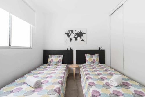 梅莱纳拉Piso en primera linea con vistas directas al mar的白色墙壁客房中的两张单人床
