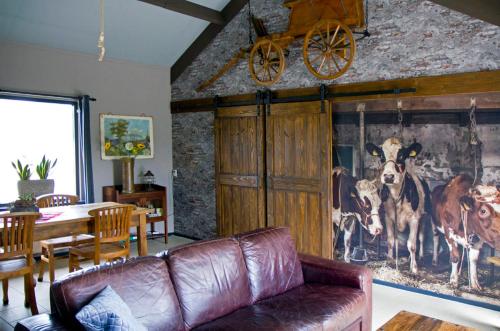 埃德De Deel - Vakantiehuisje Veluwe的客厅配有沙发和牛油画
