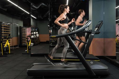 珀斯珀斯QT酒店的两个女人在健身房跑步机上行走