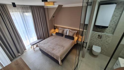 阿赫托波尔NEA Apartments的一间带一张床和淋浴的小卧室