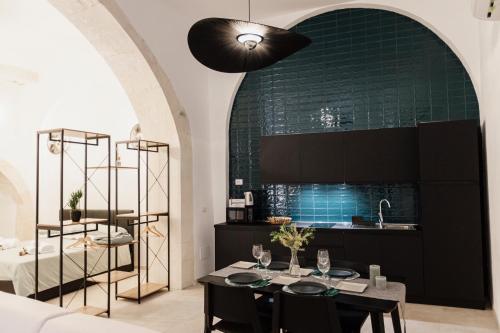 锡拉库扎I Dammusi di Via Vittorio Veneto的厨房配有桌子和绿色的墙壁