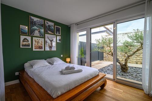 瓦讷LA P'TITE VANNETAISE - Petite maison au bord de l'eau à Conleau avec vélos的一间卧室设有一张床和绿色的墙壁