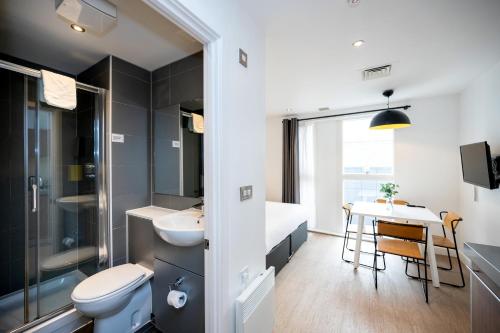 伯明翰Staycity Aparthotels Birmingham Jewellery Quarter的一间带水槽、卫生间和桌子的浴室