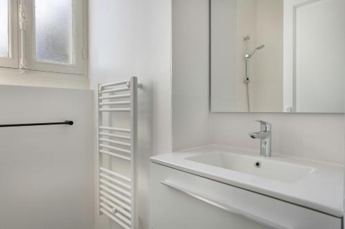 勒克鲁西克Bel appartement vue sur le port du Croisic的白色的浴室设有水槽和镜子