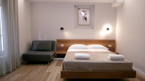 地拉那KONI's Studio Apartments的一间卧室配有一张床和一把椅子