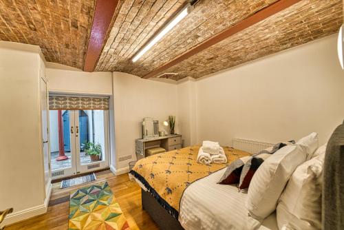 伍斯特Guest Homes - The Basement On The Tything的一间卧室设有一张床和砖砌天花板