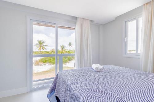 科斯塔萨乌佩SA06 Excelente Casa 5 Quartos - Reserva de Sauípe的一间卧室配有一张床,享有海滩美景
