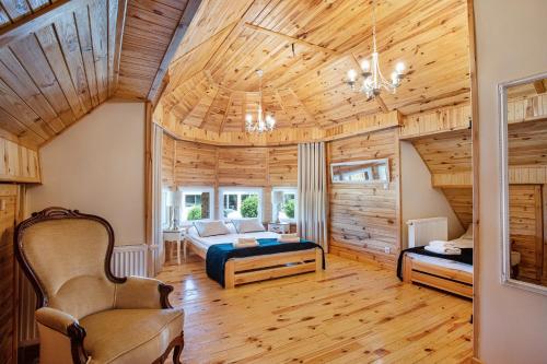 Stare MiastoSkansen Bicz Resort的一间带一张床的卧室,位于带木制天花板的房间内