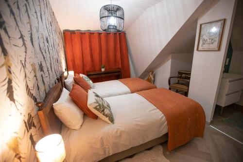 罗什科尔邦Chambre Jungle dans maison d'hote "Le Petit Clouet"- Rochecorbon的一间卧室配有一张带橙色窗帘的床