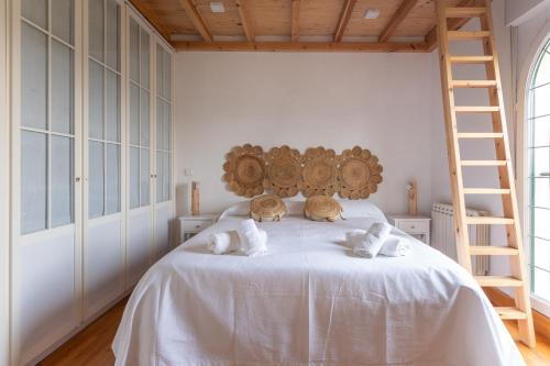 Puente ArceFidalsa Majestic的一间卧室配有一张带白色床单和梯子的床。