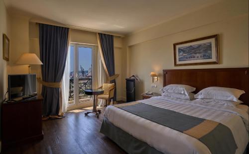 沃洛斯沃洛斯宫殿酒店的酒店客房设有一张大床和一个阳台。