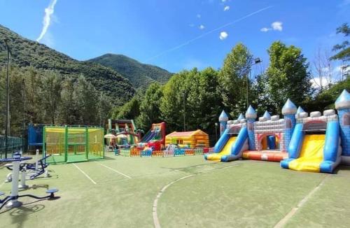 波尔莱扎Chalet Rent Porlezza的一个带五颜六色游戏场的儿童游乐场