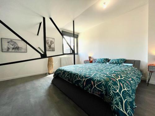 勒芒Residence Belfort的一间卧室配有一张带绿色棉被的床