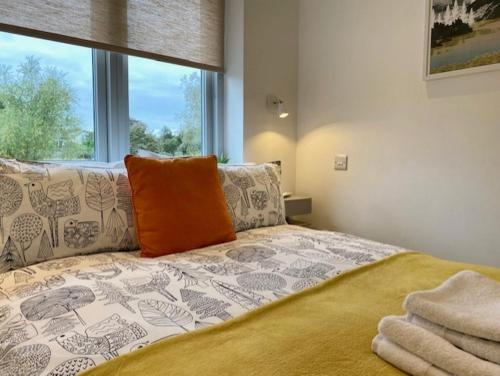 纽马基特72 Ashley Road的一间卧室配有一张带橙色枕头的床