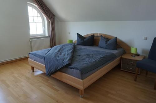 石勒苏益格Villa Ostgardie的一间卧室配有一张带蓝色枕头的床和一扇窗户。