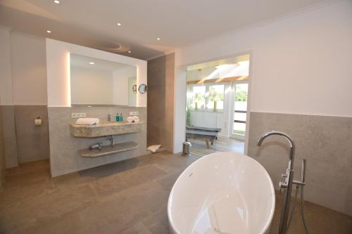 BosauLandhaus Hideaway mit Aussenpool, Sauna und Kamin的浴室配有盥洗盆和浴缸。